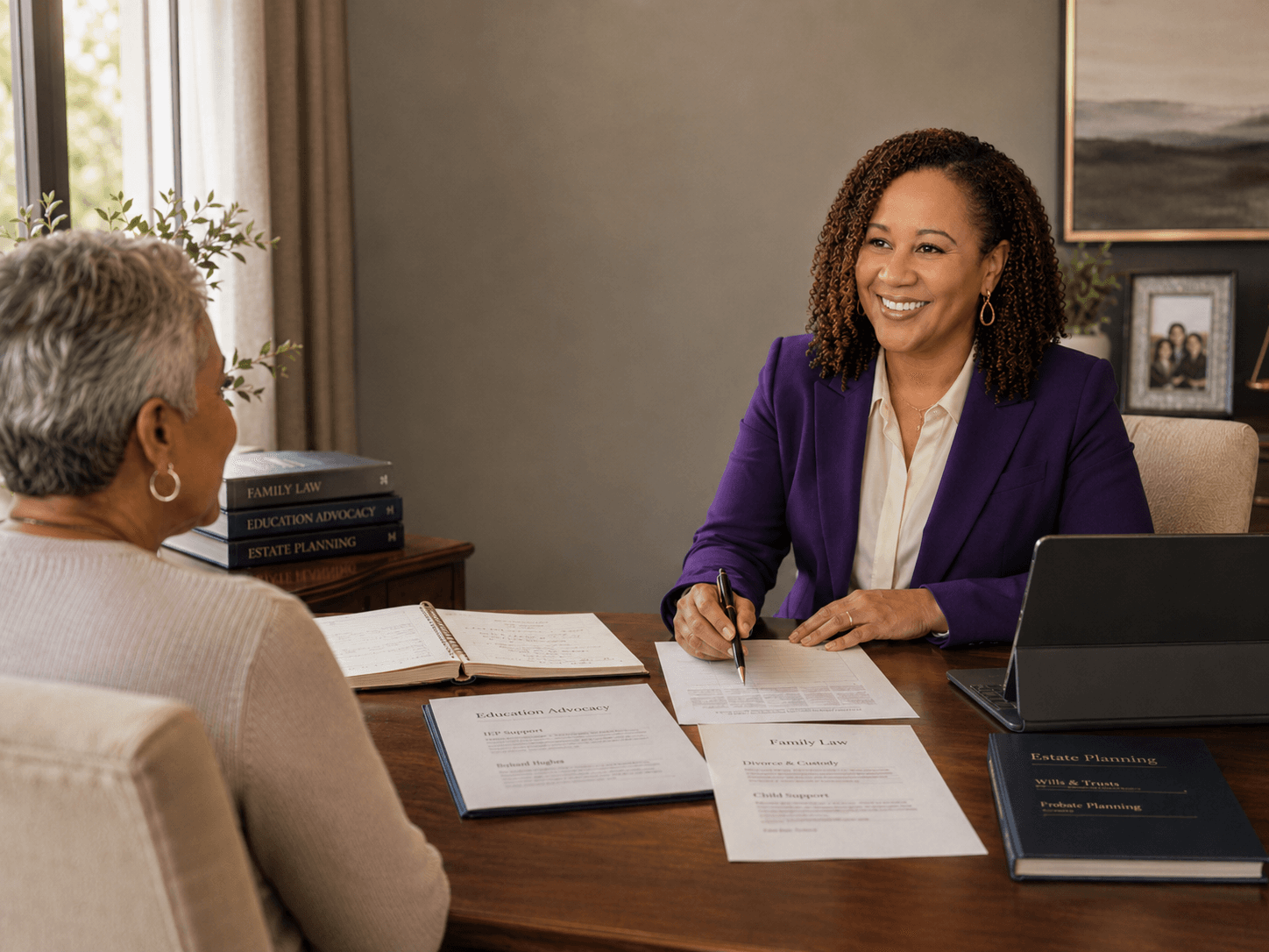 Smiling attorney in a purple blazer reviews legal documents with a client at her desk.